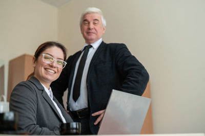 Portrait of smiling businesswoman with colleague at office