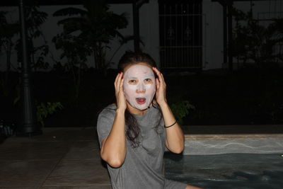 Portrait of woman wearing facial mask at night 