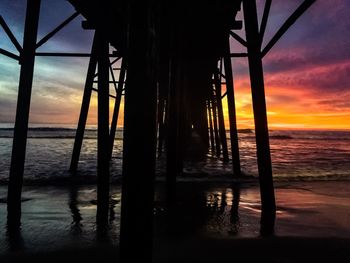 Silhouette pier on sea against sky during sunset