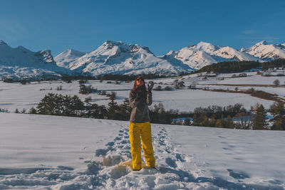 Rear view of woman standing on snow covered mountains