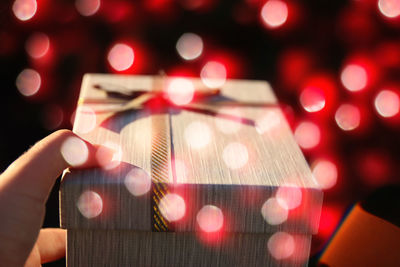 Close-up of hand holding illuminated christmas lights
