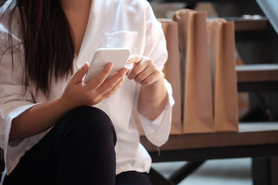 Midsection of woman using mobile phone