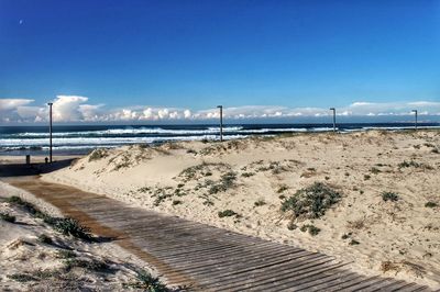 Scenic view of beach against blue sky