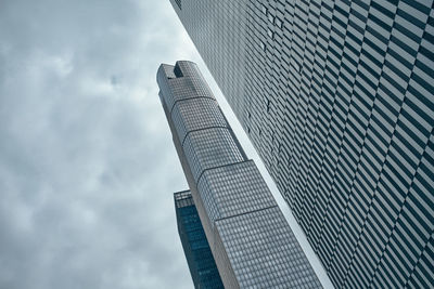 Low angle view of modern building against cloudy sky
