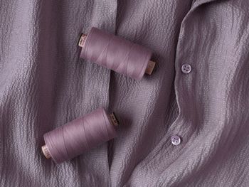 Close-up of purple spools on shirt