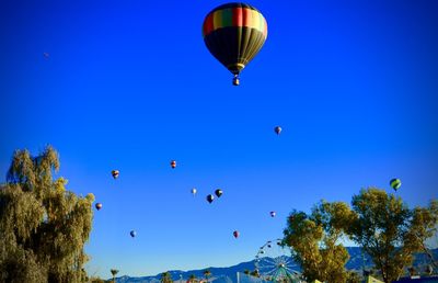 Low angle view of hot air balloon against clear blue sky