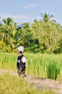 Rear view of man standing on field against sky