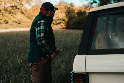 Low section of man photographing on field