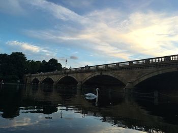 Arch bridge over river against sky