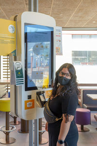 Mallorca, spain, 07-27-2021,young woman placing an order on a touch screen in macdonalds 
