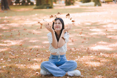 Smiling young woman sitting on field