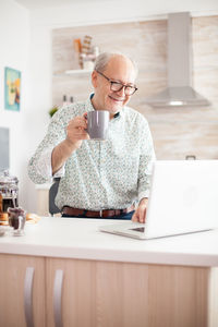 Midsection of man using mobile phone while sitting on table