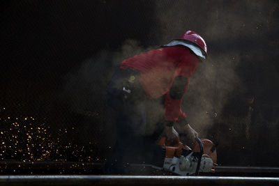 Side view of welder welding at workshop