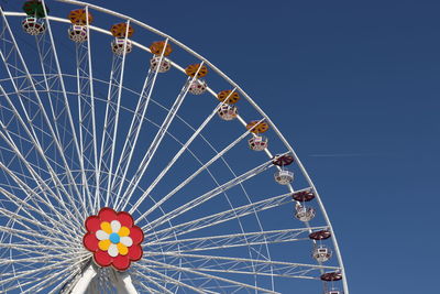 Low angle view of ferris wheel against blue sky