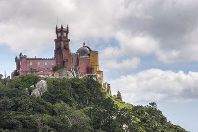 Low angle view of old building against cloudy sky