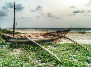 Weathered boat moored on shore at tarkarli beach