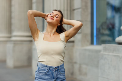 Young woman standing against wall