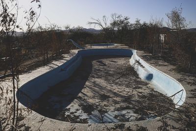 Abandoned boat moored on shore against sky