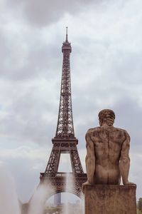 Low angle view of statue of tower against cloudy sky