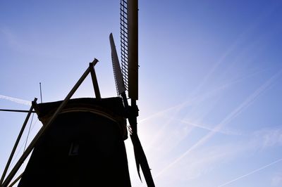 Low angle view of crane against clear blue sky