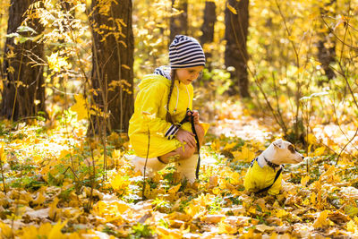 Boy with yellow umbrella in forest