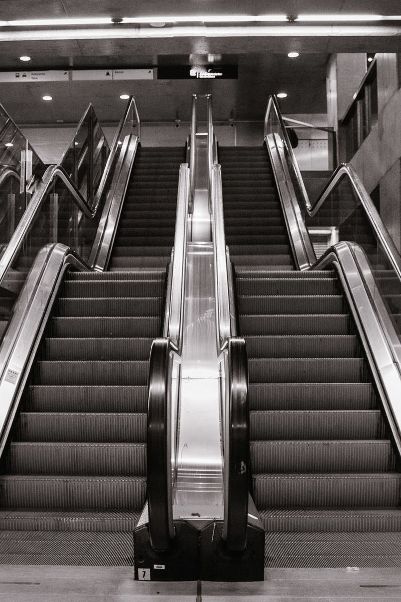 staircase, steps and staircases, indoors, convenience, railing, escalator, transportation, architecture, technology, illuminated, no people, the way forward, direction, subway station, built structure, high angle view, absence, modern, empty, metal, moving walkway