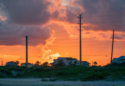 Electricity pylon against sky during sunset