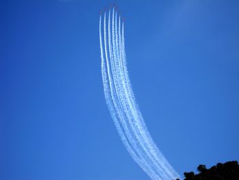 Low angle view of airplane flying against clear blue sky