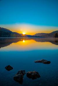 Scenic view of lake against sky during sunset