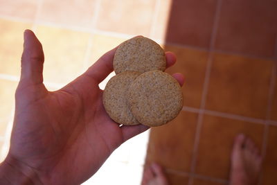 Close-up of person holding hand on tiled floor