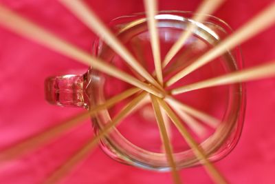 Close-up of cocktail stick arranged in glass over pink background