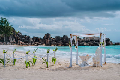 Chairs on beach against sky