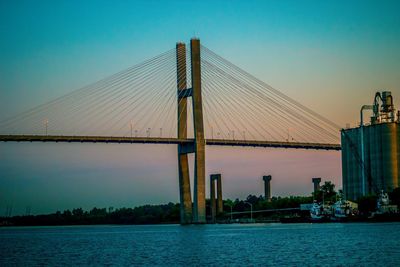 View of bridge over calm sea at sunset