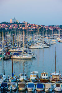 Boats moored at harbor against clear sky