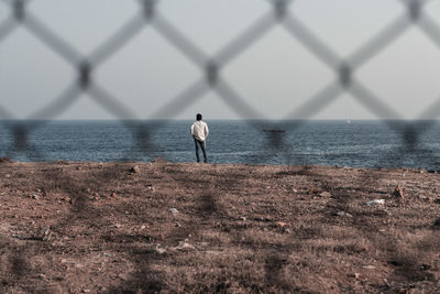 Rear view of man standing on sea shore