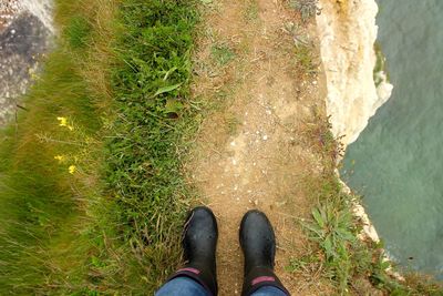 Low section of man standing on cliff