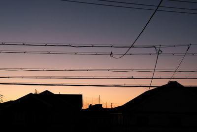 Low angle view of silhouette buildings against sky at sunset