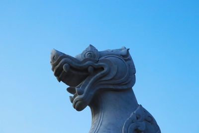 Low angle view of statue against clear blue sky