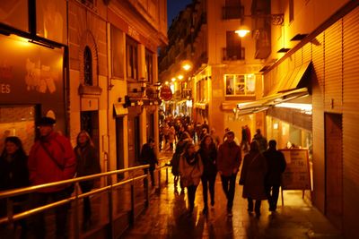 People walking in illuminated city at night