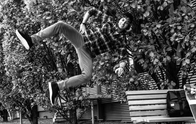 Young man jumping against trees