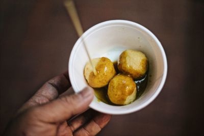 Close-up of hand holding soup in bowl