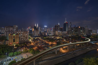 Illuminated cityscape against sky at night