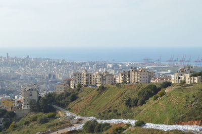 High angle view of cityscape by sea against sky