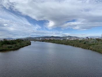 Scenic view of river against sky in city