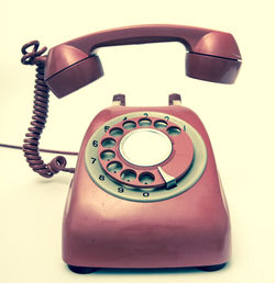 Close-up of telephone against yellow background