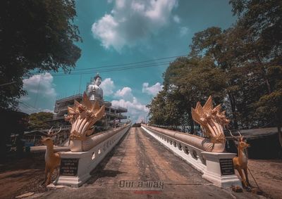 Panoramic view of road by trees against sky