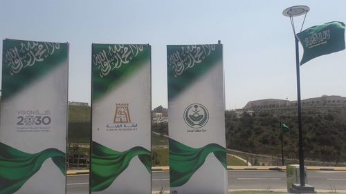 Information sign on road in city against clear sky