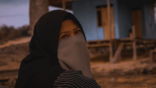 Close-up portrait of young woman standing outdoors