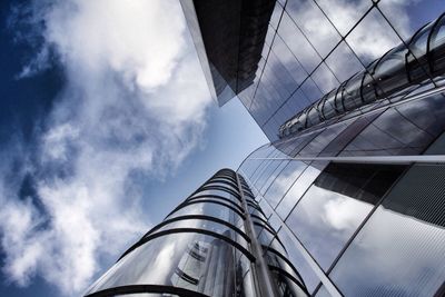 Low angle view of modern building against cloudy sky