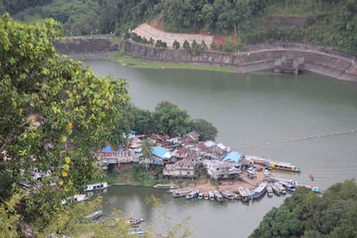 High angle view of river amidst trees and buildings